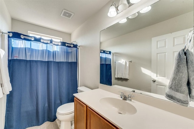 bathroom featuring visible vents, toilet, a shower with shower curtain, and vanity