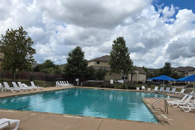 community pool with a patio and fence