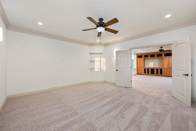 spare room with ceiling fan, crown molding, and carpet