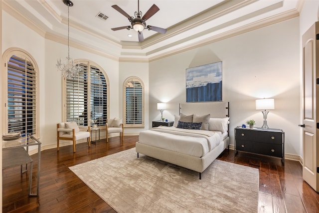 bedroom with hardwood / wood-style floors, a raised ceiling, ornamental molding, and ceiling fan with notable chandelier