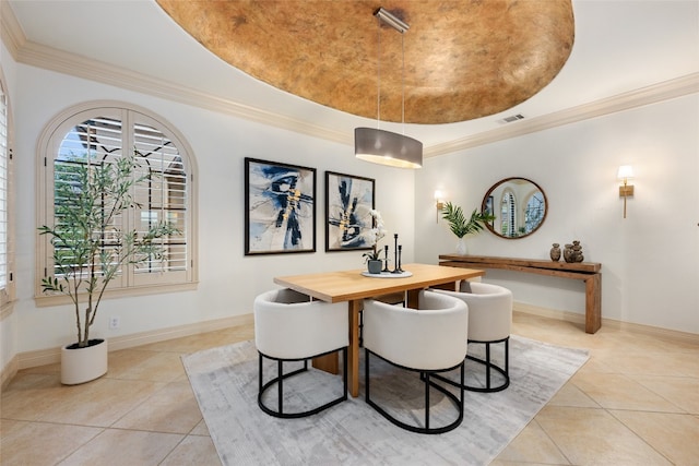 tiled dining space featuring a tray ceiling and crown molding