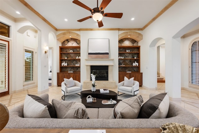 tiled living room featuring built in features, ceiling fan, and ornamental molding