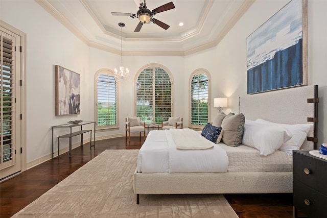 bedroom featuring dark wood-type flooring, ceiling fan with notable chandelier, crown molding, and a tray ceiling