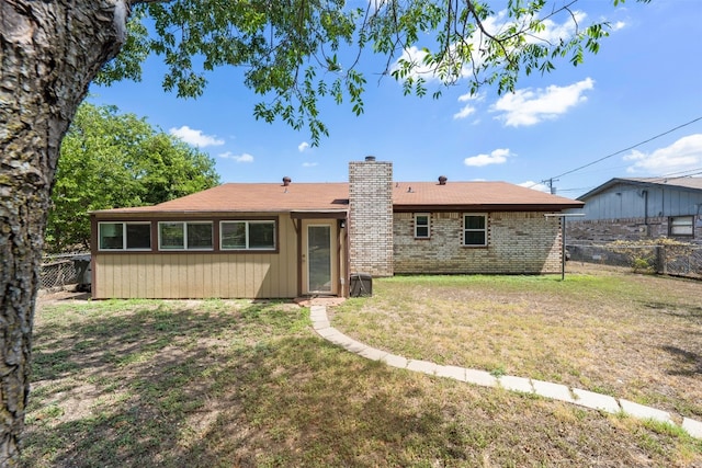 rear view of property with a yard