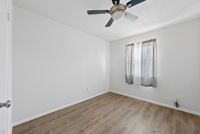 empty room featuring ceiling fan and light hardwood / wood-style flooring