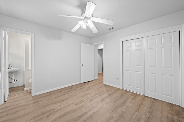 unfurnished bedroom with light hardwood / wood-style flooring, connected bathroom, ceiling fan, and a closet