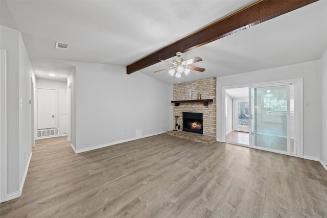 unfurnished living room with light hardwood / wood-style flooring, ceiling fan, lofted ceiling with beams, and a fireplace