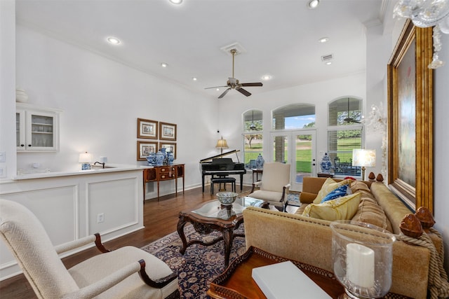 living room with dark wood-type flooring, ceiling fan, crown molding, and french doors