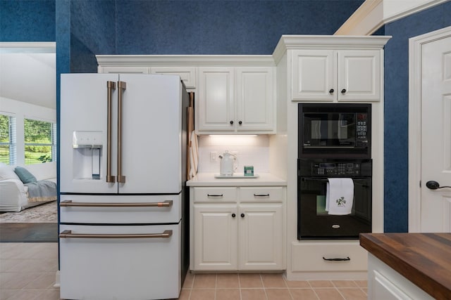 kitchen featuring light tile patterned floors, white cabinetry, black appliances, wood counters, and decorative backsplash