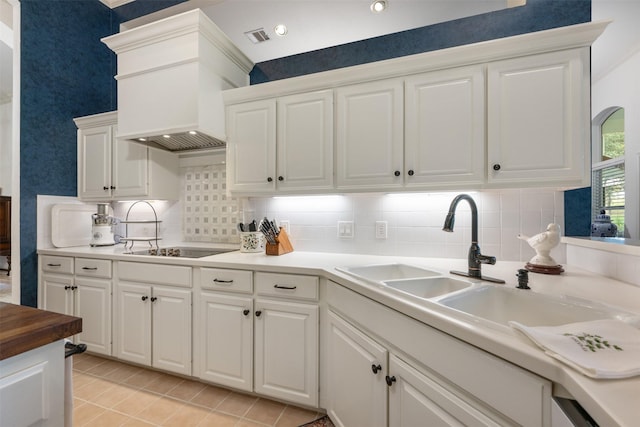 kitchen featuring tasteful backsplash, white cabinetry, and black electric stovetop