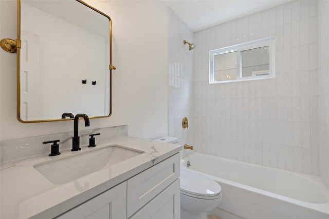 full bathroom with tiled shower / bath, toilet, and vanity