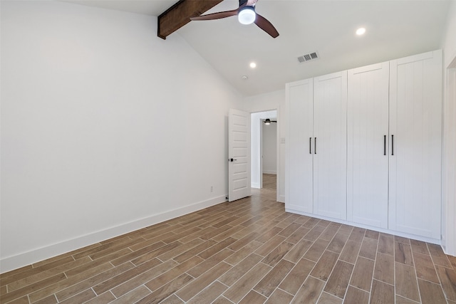 unfurnished bedroom featuring hardwood / wood-style floors, ceiling fan, and vaulted ceiling with beams