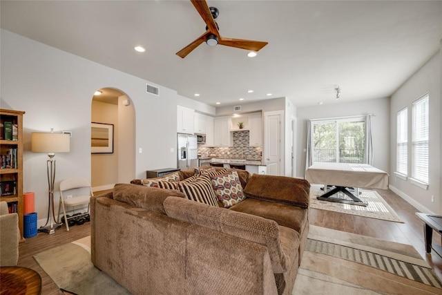 living room with ceiling fan and light wood-type flooring