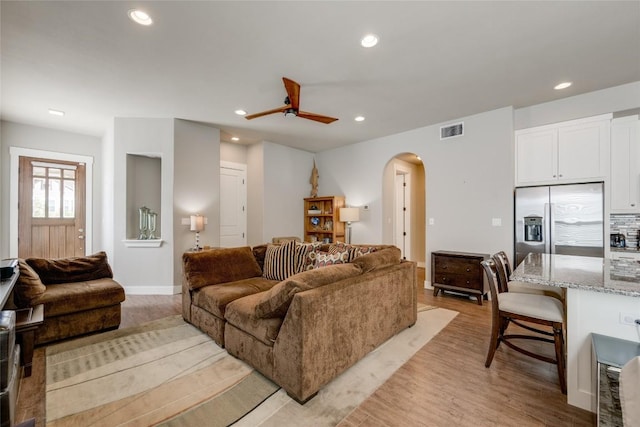 living room with ceiling fan and light hardwood / wood-style flooring