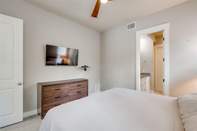 bedroom featuring ensuite bathroom, ceiling fan, and light colored carpet