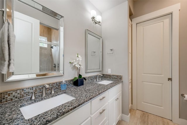 bathroom with hardwood / wood-style floors, vanity, and backsplash