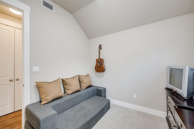 living area featuring light colored carpet and lofted ceiling