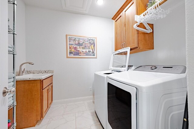 laundry room with cabinets, separate washer and dryer, and sink