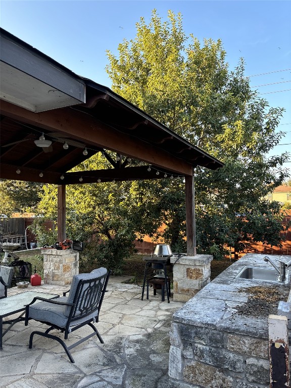 view of patio with a grill, area for grilling, a wet bar, a gazebo, and ceiling fan