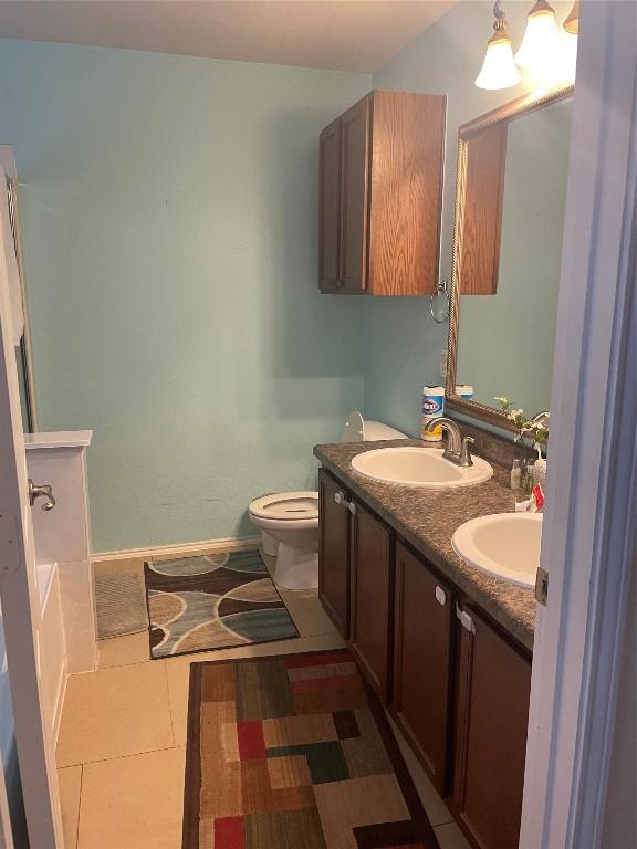 full bath featuring double vanity and toilet