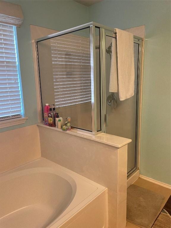 full bathroom featuring a stall shower and a bath