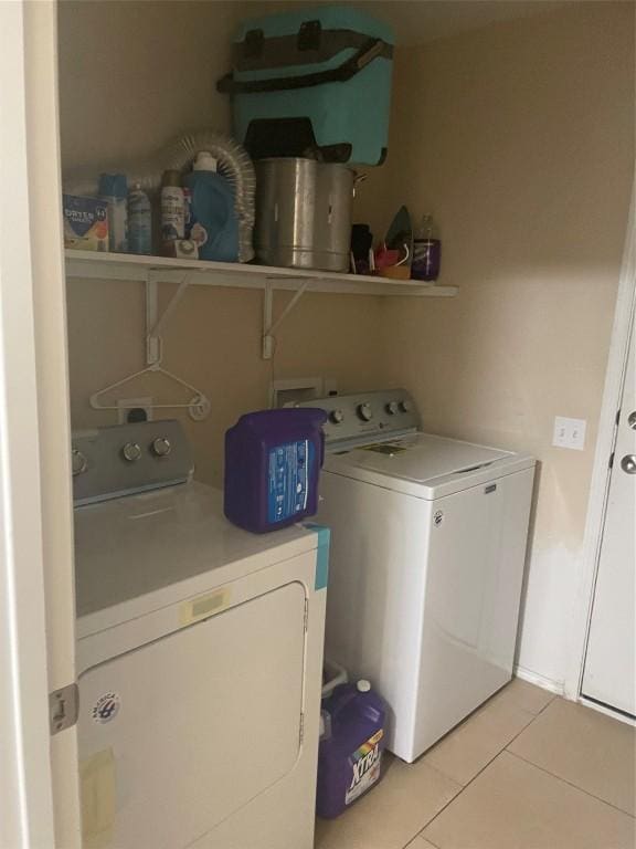 laundry area with washer and dryer and light tile patterned flooring