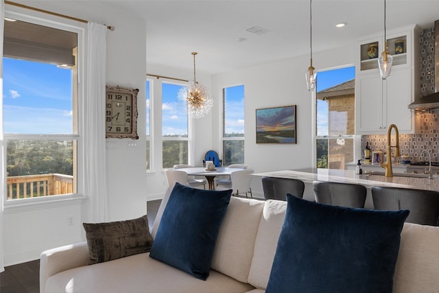 living area featuring baseboards, a chandelier, wood finished floors, and recessed lighting