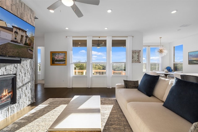 living area featuring ceiling fan with notable chandelier, a fireplace, wood finished floors, and recessed lighting