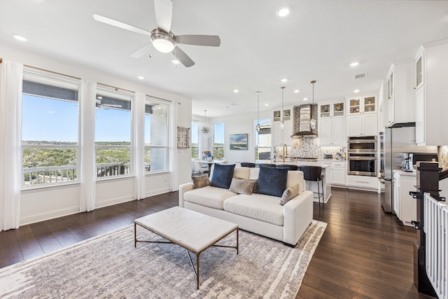 living room featuring recessed lighting, dark wood-style flooring, visible vents, and ceiling fan