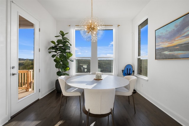 dining space with dark wood-style floors, baseboards, and a notable chandelier