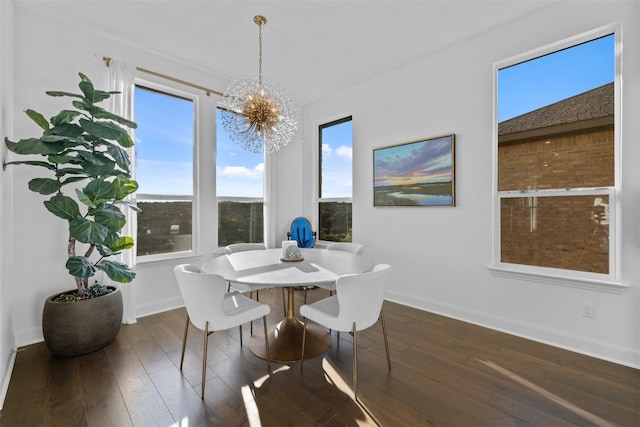 dining area with baseboards, dark wood finished floors, and a notable chandelier