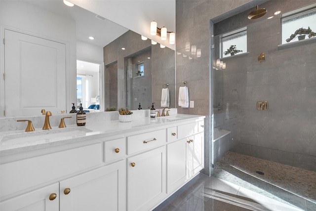 bathroom featuring double vanity, a sink, and a walk in shower