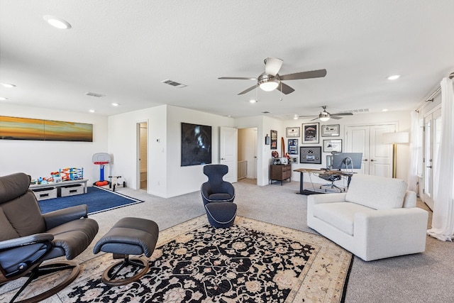 living room featuring carpet, visible vents, a textured ceiling, and recessed lighting