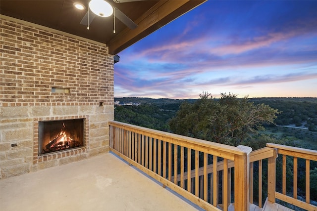 balcony with an outdoor brick fireplace and ceiling fan