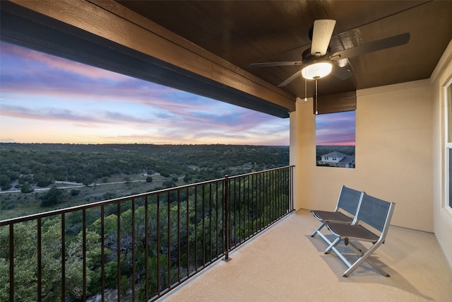 balcony at dusk featuring ceiling fan