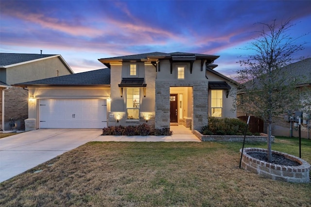 view of front of house featuring an attached garage, concrete driveway, a yard, stone siding, and stucco siding