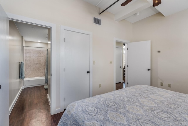 bedroom with ceiling fan, beamed ceiling, and dark wood-type flooring