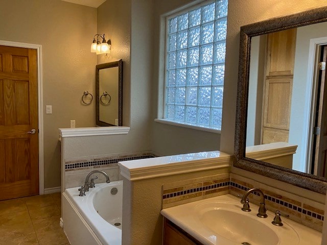 bathroom featuring a healthy amount of sunlight, a bathing tub, vanity, and tile patterned floors