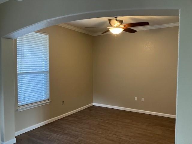 spare room featuring ceiling fan, dark hardwood / wood-style flooring, and crown molding