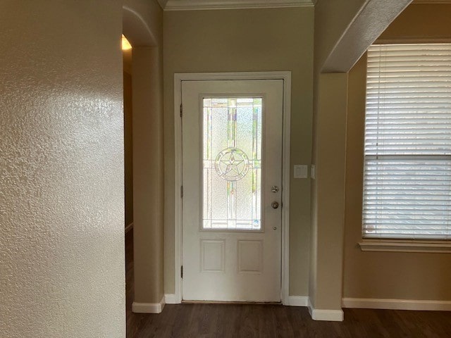 entryway featuring ornamental molding and dark hardwood / wood-style flooring