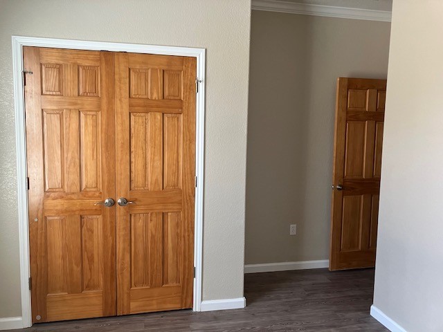 hall featuring crown molding and dark hardwood / wood-style floors