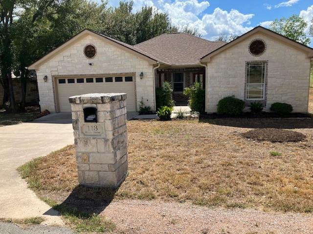 single story home featuring driveway, a shingled roof, and an attached garage