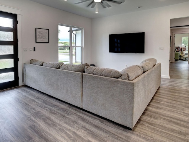 living room featuring hardwood / wood-style floors and ceiling fan