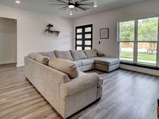 living room featuring wood-type flooring and ceiling fan