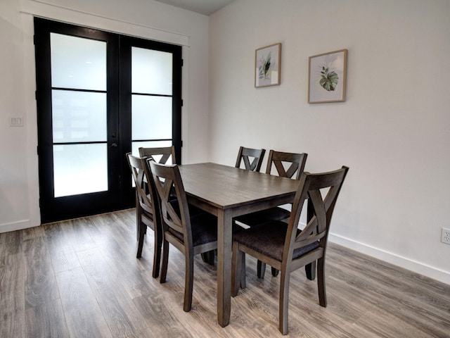 dining space featuring wood-type flooring and french doors