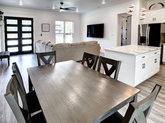 dining room featuring light hardwood / wood-style floors, ceiling fan, and french doors