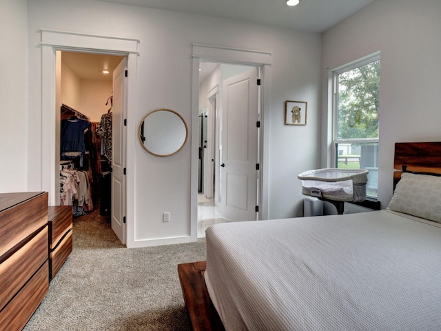 carpeted bedroom with a spacious closet and a closet