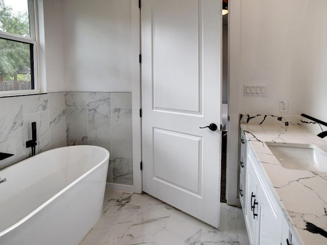 bathroom featuring tile walls, vanity, and a bath