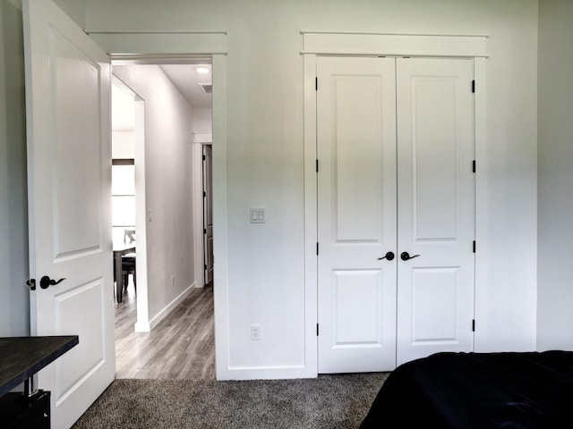 bedroom featuring dark hardwood / wood-style floors and a closet