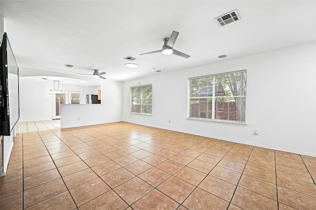 unfurnished living room featuring light tile patterned floors and ceiling fan